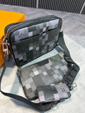 A matching three-piece crossbody bag set with a pixelated geometric pattern in black, gray, and light purple, displayed on a gray surface with a Louis Vuitton box partially visible.