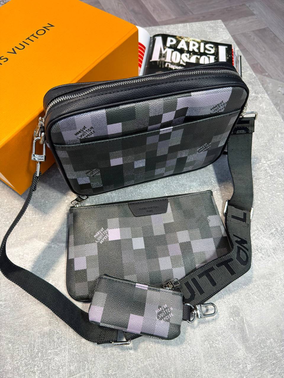 Louis Vuitton monogram crossbody bag set in black and gray pixelated canvas, including a crossbody bag, matching pouch, coin purse, and branded orange box.