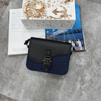 Black and blue handbag on a textured surface with books in the background